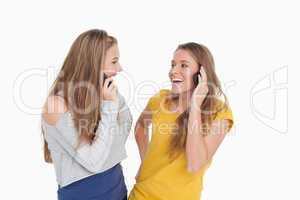 Two young women laughing on the phone together
