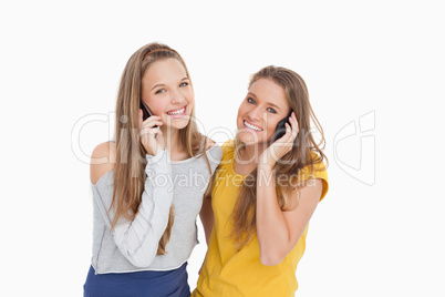 Two young women smiling on the phone