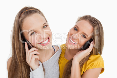 Close-up of two young women smiling on the phone