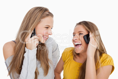Close-up of two young women laughing on the phone