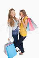 Two beautiful young women with shopping bags the thumb-up