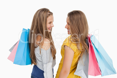 Rear view of two young women with shopping bags