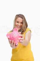 Young smiling woman tending a piggy-bank