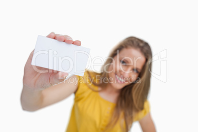 Close-up of a blond woman showing a white card