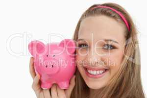 Close-up of a young woman holding a piggy-bank