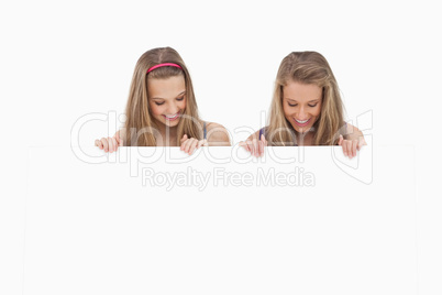 Close-up of two young women holding a blank board