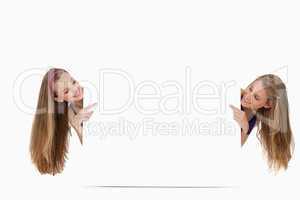 Two long hair women back of a blank sign