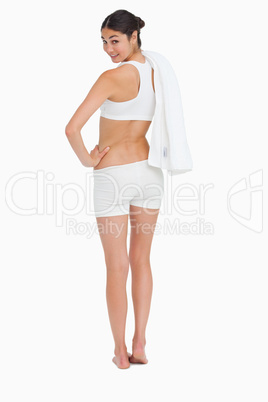 Rear view of a smiling slim woman holding a towel