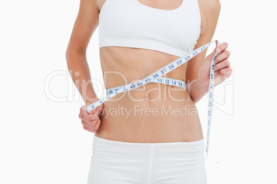 Close-up of a woman on diet measuring her waist