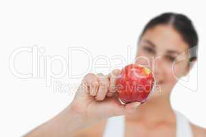 Close-up on a apple holding by a brunette