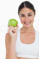 Close-up a brunette holding an green apple