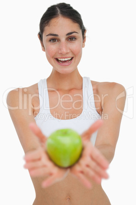 Close-up a brunette showing a green apple