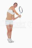 Slim brunette playing tennis in white clothes