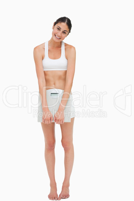 Slim young woman holding a scales