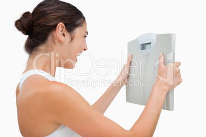 Young woman happy while holding a scales