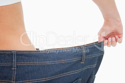Close-up of a woman waist in a too big pants