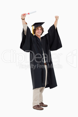 Male student in graduate robe raising his arms