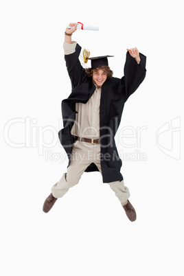 Male student in graduate robe jumping