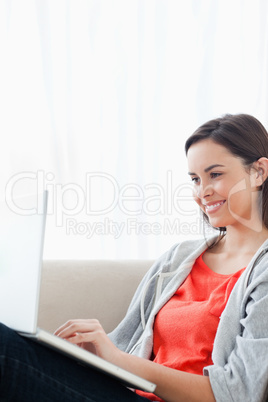 Smiling woman using her laptop on the couch