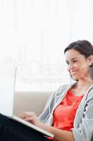 Smiling woman using her laptop on the couch
