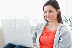 A woman with a lovely smilw using her laptop