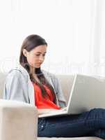 Woman using her laptop as she sits on the couch