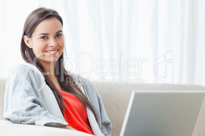 Half length shot of a smiling woman on the couch looking into th