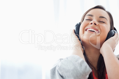 A laughing woman listening to her headphones