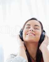 Close up shot of a smiling woman listening to her headphones