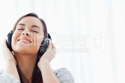 A smiling woman listening to her headphones