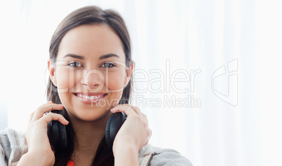 A smiling woman with headphones looks into the camera