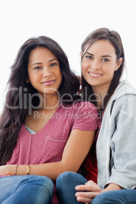 Half length shot of two women lying against each other while loo