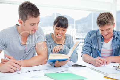 A group of students sitting together as they all study