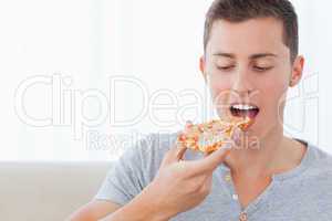 A man looking at the slice of pizza he is about to eat