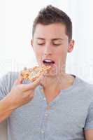Close up of a man as he is about to eat the slice of pizza he is