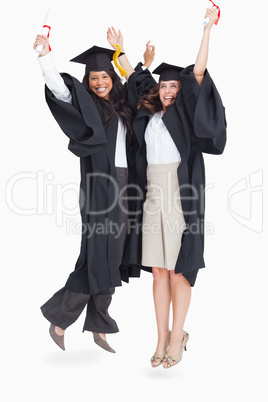 Full length of two women celebrating in the air