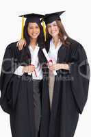 Two women embracing each other after they graduated from univers