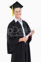 A smiling man looking at the camera as he graduates