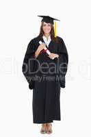 Full length shot of a graduate holding a degree and looking at t