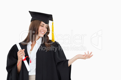 A woman holding her hand out with a degree in her other hand as