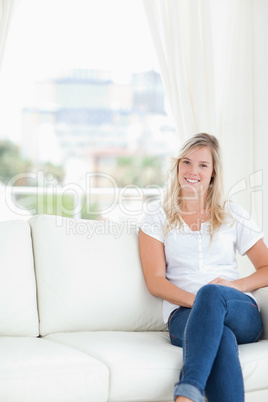 A smiling woman with her legs crossed