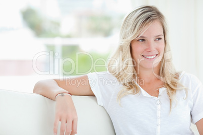 A smiling woman looking to the side as she sits