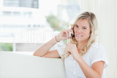 A woman looking at the camera as she talks on the phone