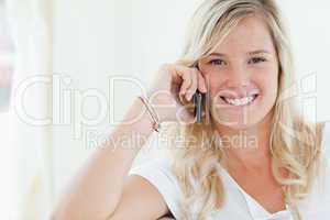 Close up shot of a woman smiling as she talks on her phone