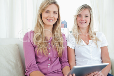 Friends sitting beside each other as they look at the camera