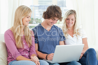Man uses his laptop while the girls watch him