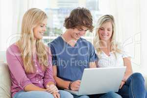 Man uses his laptop while the girls watch him
