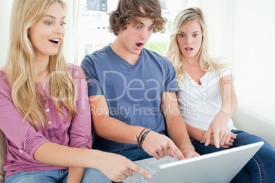 three friends shocked at what is on the laptop screen