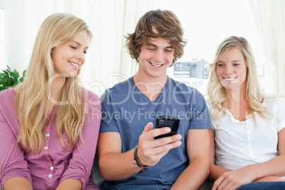 Three friends sitting and looking into the phone