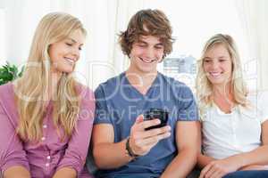 Three friends sitting and looking into the phone